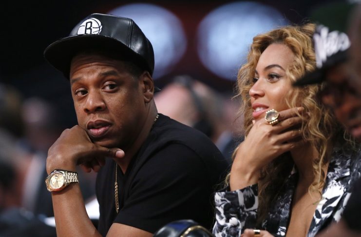 Singer Beyonce and her husband Jay-Z sit courtside at the NBA All-Star basketball game in Houston