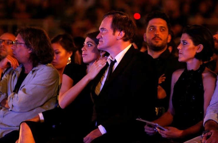 Director Quentin Tarantino sits next to Israeli singer Daniella Pick before receiving an award during the opening ceremony of the 33rd Jerusalem Film Festival in Jerusalem