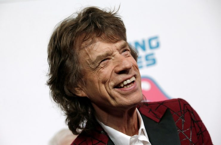 Mick Jagger of The Rolling Stones poses for photographers as the band arrives for the opening of the new exhibit “Exhibitionism: The Rolling Stones”in New York