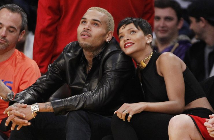 Recording artist Rihanna leans her head on Chris Brown as they sit together at the NBA basketball game between the New York Knicks and Los Angeles Lakers in Los Angeles