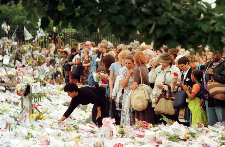 MOURNERS STAND AROUND FLOWERS OUTSIDE KENSINGTON PALACE