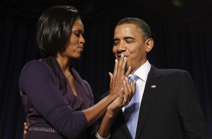 US first lady Obama wipes lipstick from US President Obama after kissing him in Washington