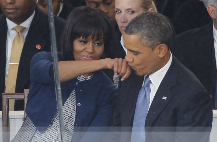 US President Barack Obama kisses First lady Michelle Obamas hand in the reviewing stand during the inaugural parade in Washington