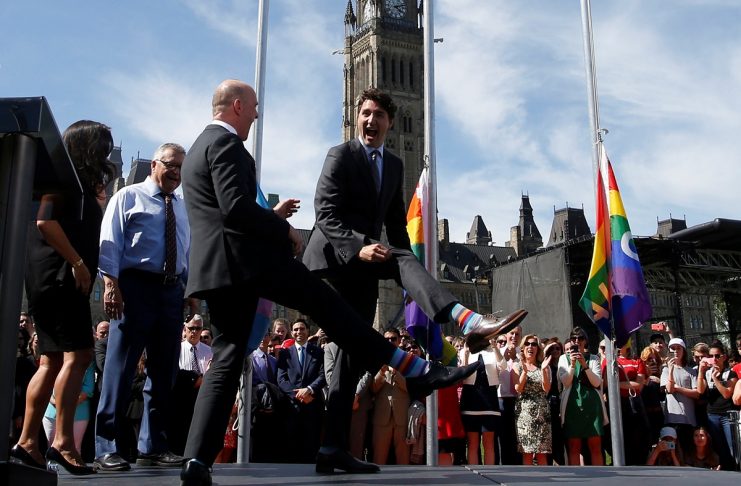 Canada’s Prime Minister Justin Trudeau compares socks with Liberal MP Randy Boissonnault during a pride flag raising ceremony on Parliament Hill in Ottawa, Ontario