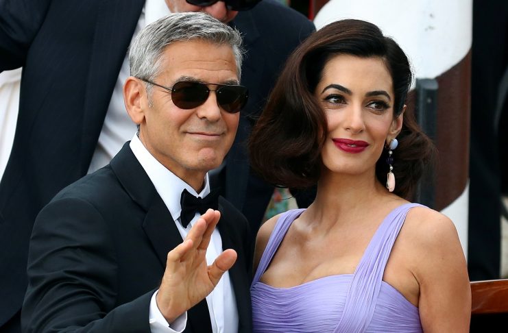 Actor and director George Clooney waves next to his wife Amal as they leave the hotel before the red carpet for the movie Suburbicon at the 74th Venice Film Festival in Venice
