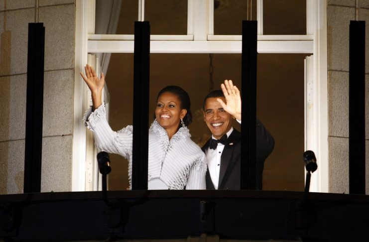 U.S. President Barack Obama and his wife Michelle acknowledge well-wishers from the balcony of the Grand Hotel in Oslo