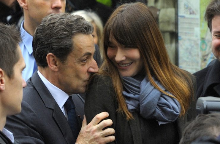France’s President and UMP party candidate for the 2012 French presidential elections Sarkozy kisses the shoulder of his wife Carla Bruni-Sarkozy in Paris