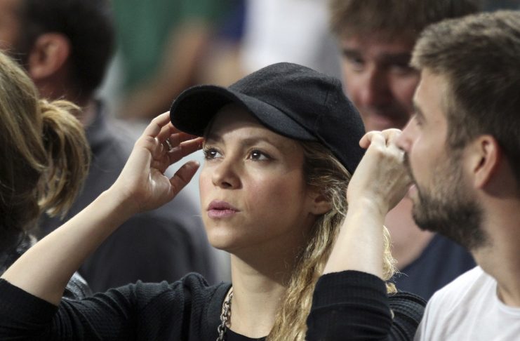 Colombia’s singer Shakira adjusts her cap beside her partner Barcelona’s soccer player Gerard Pique as they attend the Basketball World Cup quarter-final game between U.S. and Slovenia in Barcelona