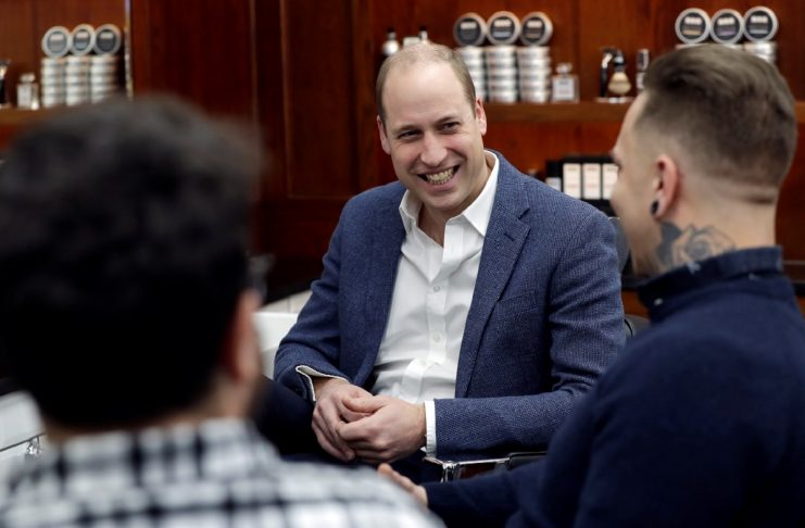 Britain’s Prince William speaks to speaks to Dean Hamilton and Paul Richardson during a visit to Pall Mall Barbers in London