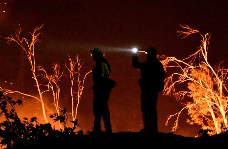 Firefighters keep watch on the Thomas wildfire in the hills and canyons outside Montecito, California