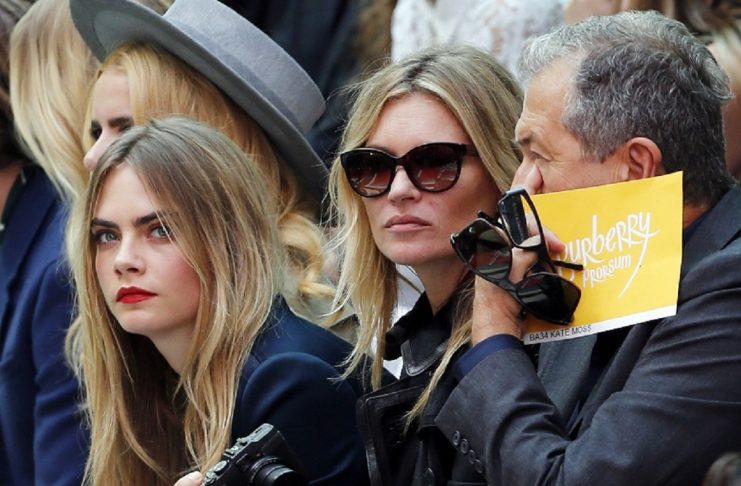 Models Cara Delevingne and Kate Moss, and photographer Mario Testino watch the presentation of the Burberry Prorsum Spring/Summer 2015 collection during London Fashion Week