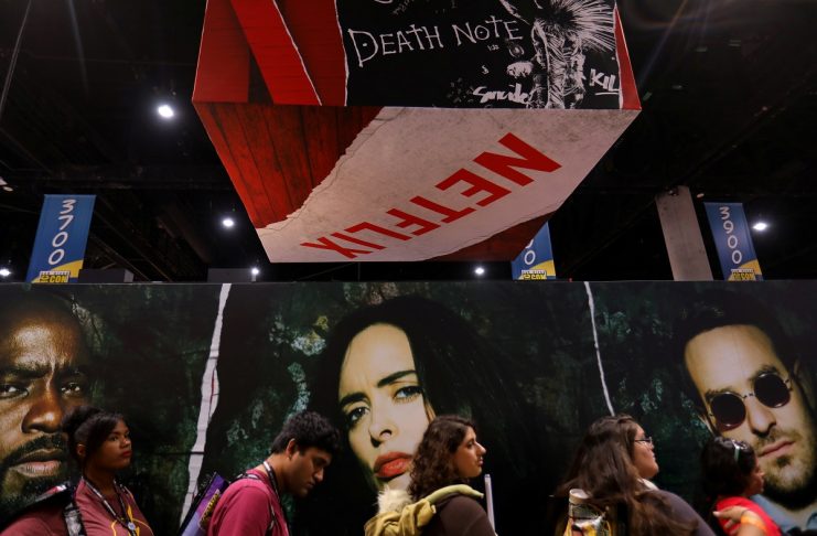 Attendees wait in line to enter the Netflix booth at Comic Con International in San Diego,