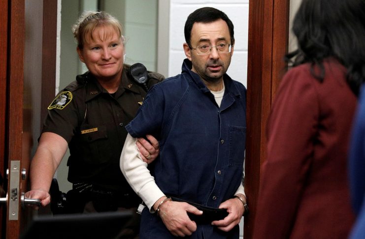 Larry Nassar, a former team USA Gymnastics doctor, who pleaded guilty in November 2017 to sexual assault charges, is escorted into the courtroom during his sentencing hearing in Lansing