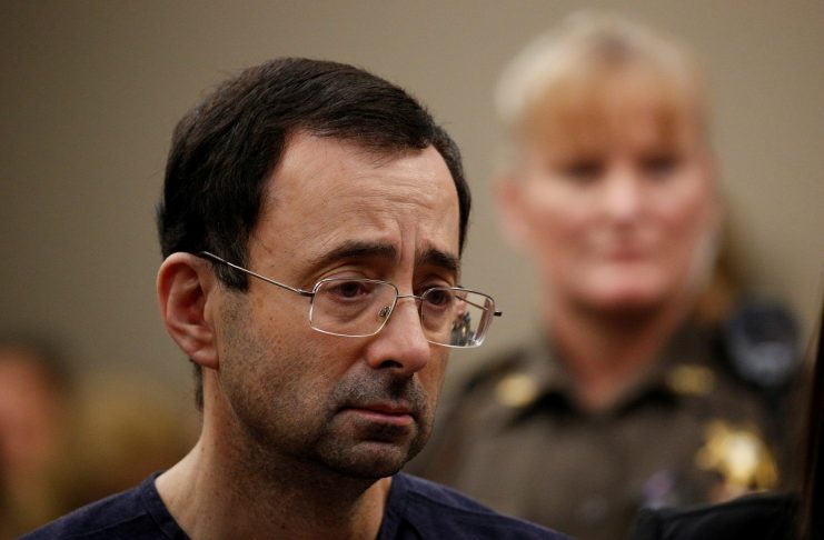 Larry Nassar, a former team USA Gymnastics doctor who pleaded guilty in November 2017 to sexual assault charges, stands with his legal team during his sentencing hearing in Lansing