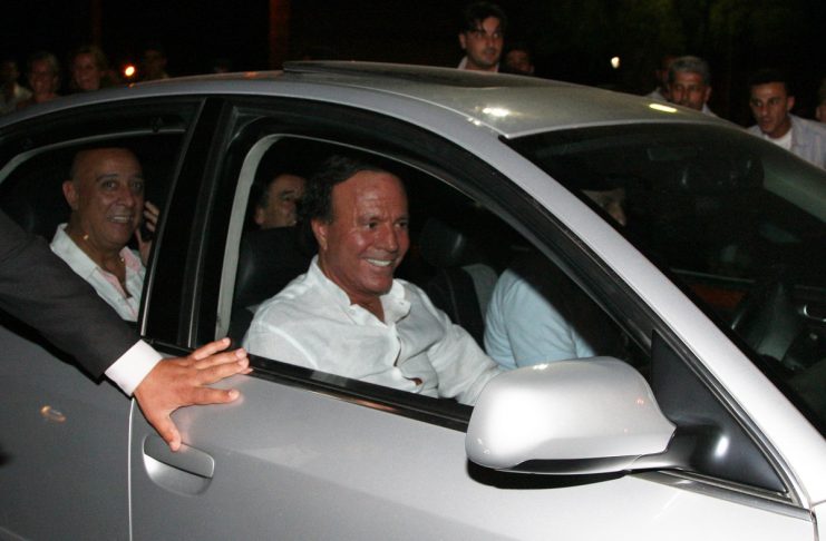 Spanish singer Julio Iglesias (front) leaves after his concert from the Busra stage