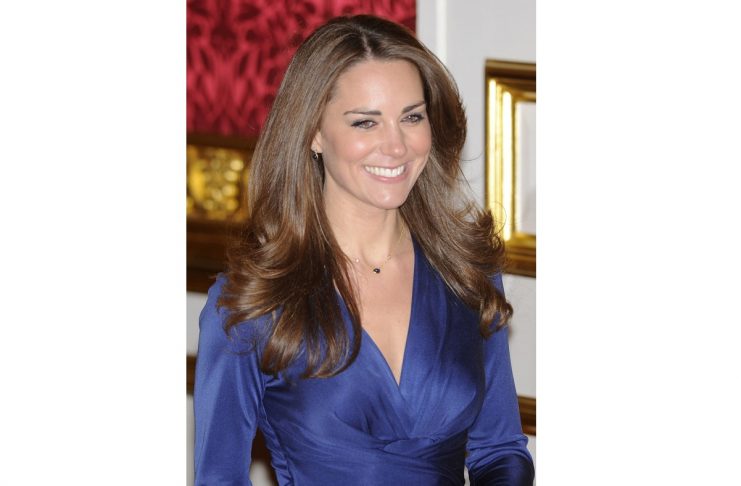 Kate Middleton enters a room with her fiance, Britain’s Prince William, to pose for a photograph in St. James’s Palace