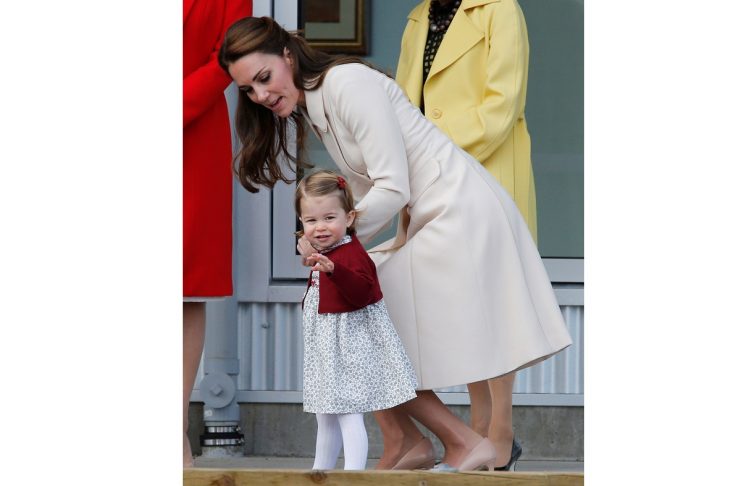 Britain’s Princess Charlotte waves as she arrives with Kate, Duchess of Cambridge, to board a floatplane for their official departure from Canada in Victoria
