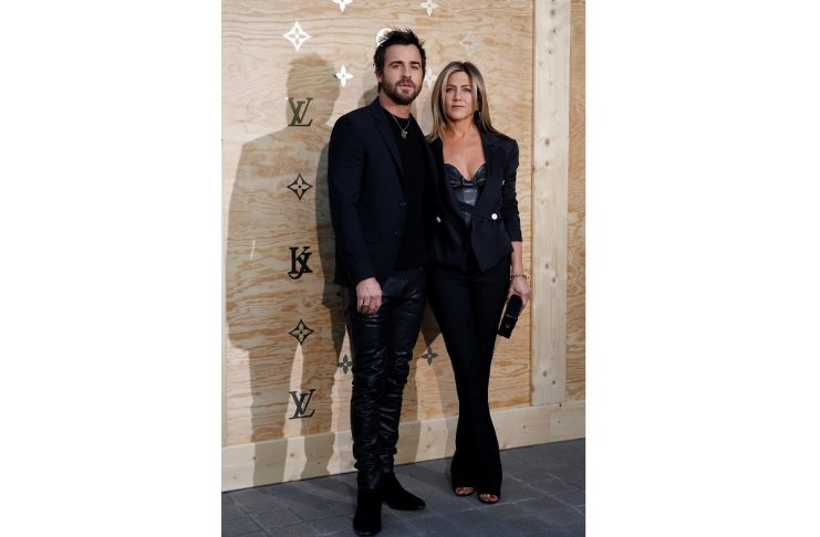 Actress Jennifer Aniston and Justin Theroux pose during a photocall as she arrives to attend a dinner organized by French luxury group Louis Vuitton for the launching of new leather accessories in Paris