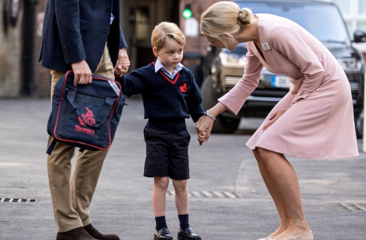 Helen Haslem, head of the lower school, greets Britain’s Prince William and his son Prince George on his first day of school at Thomas’s school in Battersea, London