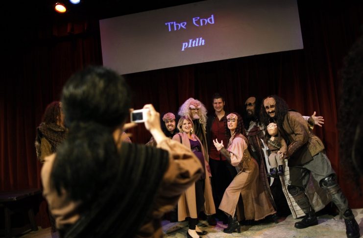 An audience member is surrounded by the cast of “A Klingon Christmas Carol” as they pose for pictures after a performance in Chicago