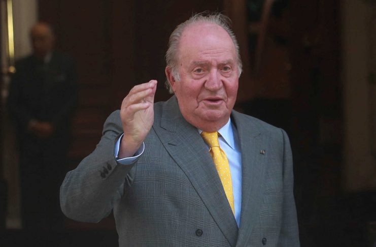 Former King of Spain Juan Carlos I waves to the media before meeting with Chile’s President-elect Sebastian Pinera in Santiago
