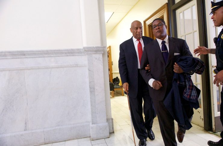 Cosby walks through the Montgomery County Courthouse with his publicist, Wyatt, after being found guilty on all counts in his sexual assault retrialin Norristown