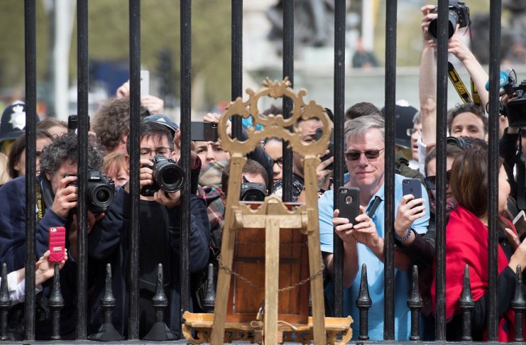 Tourists and photographers take pictures of a notice placed on an easel in the forecourt of Buckingham Palace to formally announce the birth of a baby boy to the Britain’s Catherine, the Duchess of Cambridge, and Prince William, in London