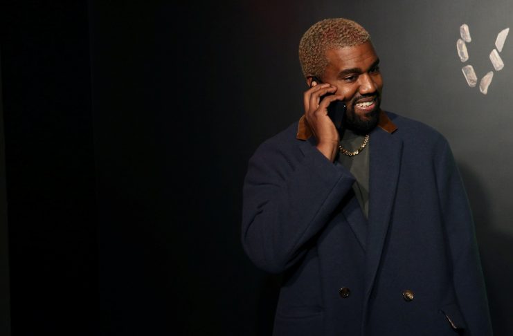 Rapper Kanye West talks on the phone before attending the Versace presentation in New York