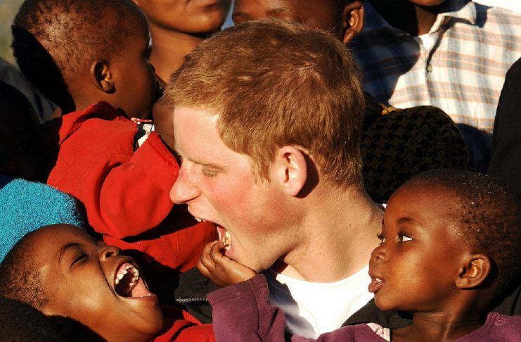 – PHOTO TAKEN 24APR06 – Britain’s Prince Harry (C) makes faces at children Mutsu (L) and Lintle (R) ..