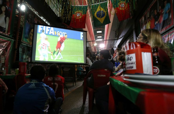 Fans watch the World Cup soccer match between Spain and Portugal at the Municipal Market of foodsin Rio de Janeiro