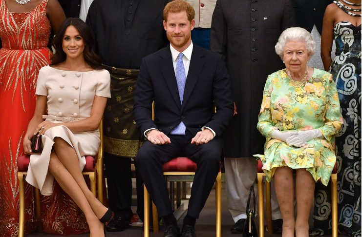 Britain’s Queen Elizabeth, Prince Harry and Meghan, the Duchess of Sussex pose for a picture with some of Queen’s Young Leaders at a Buckingham Palace reception following the final Queen’s Young Leaders Awards Ceremony, in London