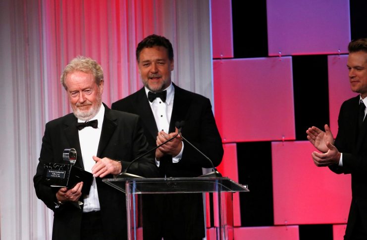 Director Scott accepts the American Cinematheque Award, as actors Crowe and Damon stand nearby, at the 30th annual American Cinematheque Award ceremony in Beverly Hills