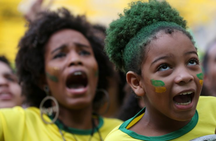 Fans react as they watch the broadcast of the World Cup Group E soccer match between Brazil and Switzerland, in Rio de Janeiro