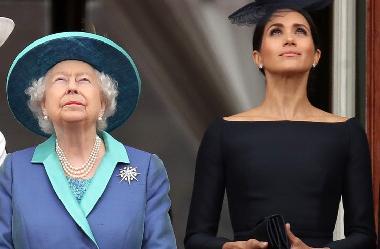 Britain’s Queen Elizabeth and Meghan, Duchess of Sussex stand on the balcony of Buckingham Palace as they watch a fly past to mark the centenary of the Royal Air Force in central London
