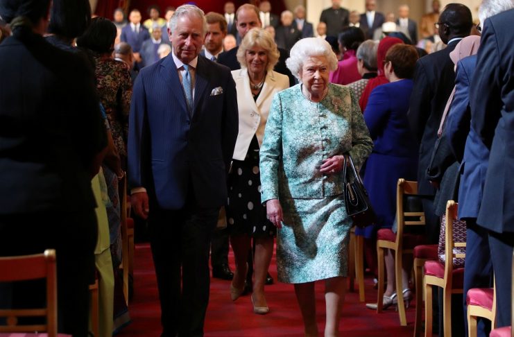 Britain’s Queen Elizabeth and Prince Charles leave after the formal opening of the Commonwealth Heads of Government Meeting in the ballroom at Buckingham Palace in London