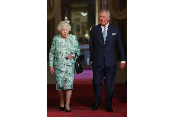 Britain’s Queen Elizabeth and Prince Charles arrive for the formal opening of the Commonwealth Heads of Government Meeting in the ballroom at Buckingham Palace in London