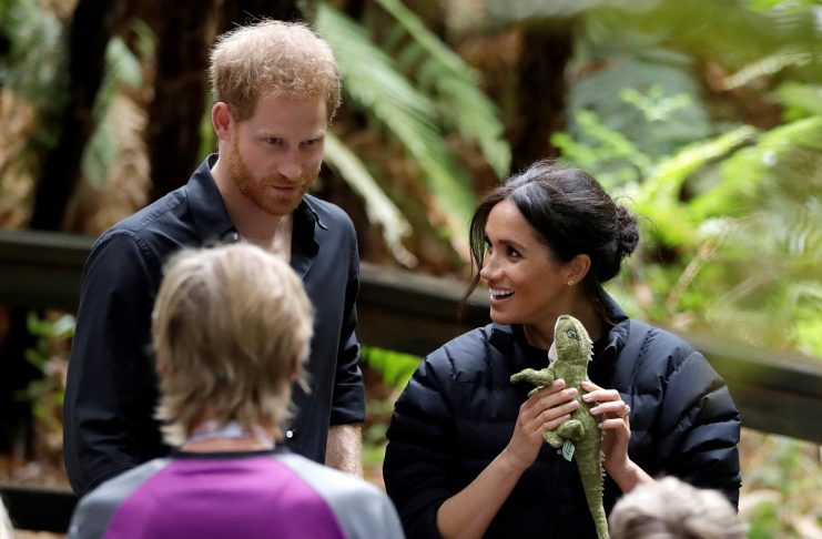 Britain’s Prince Harry and Meghan, Duchess of Sussex holds a gift during a visit to the Redwoods Treewalk Rotorua in Rotorua, New Zealand, Wednesday