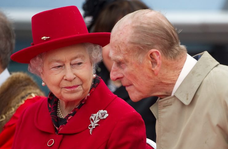 Britain’s Queen Elizabeth speaks to her husband Prince Philip as they attend the official re-opening of the Cutty Sark in Greenwich, London