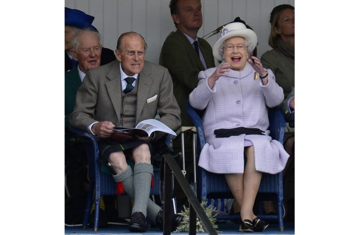 Britain’s Prince Philip and Queen Elizabeth cheer as competitors participate in a sack race at the Braemar Gathering in Braemar