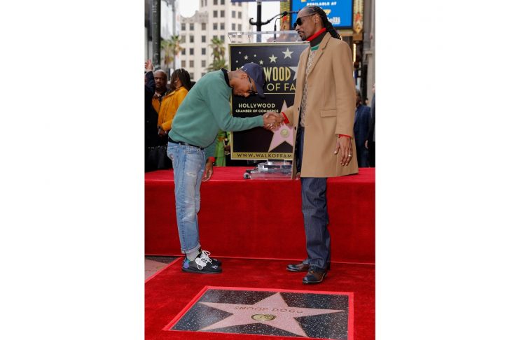 Musician Pharrell Williams congratulates rapper Snoop Dogg as he receives his star on the “Hollywood Walk of Fame” in Los Angeles