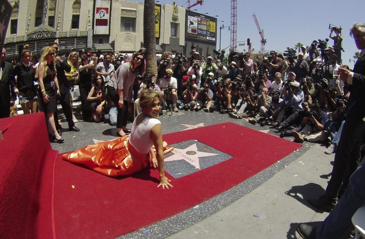 Lopez poses on her star after it was unveiled on the Walk of Fame in Hollywood