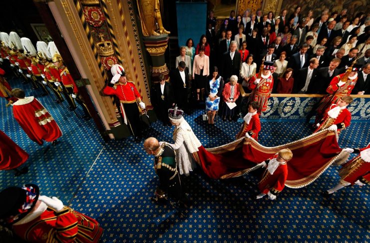 Britain’s Queen Elizabeth is accompanied by Prince Philip as they proceed through the Royal Gallery before the State Opening of Parliament in the House of Lords, at the Palace of Westminster in London