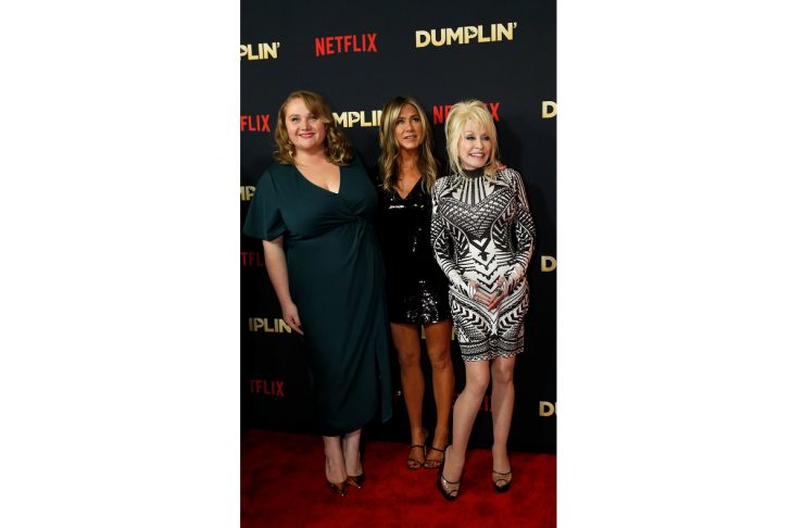 Cast members Danielle MacDonald, Jennifer Aniston and Dolly Parton interact at a premiere for the movie Dumplin’ in Los Angeles, California