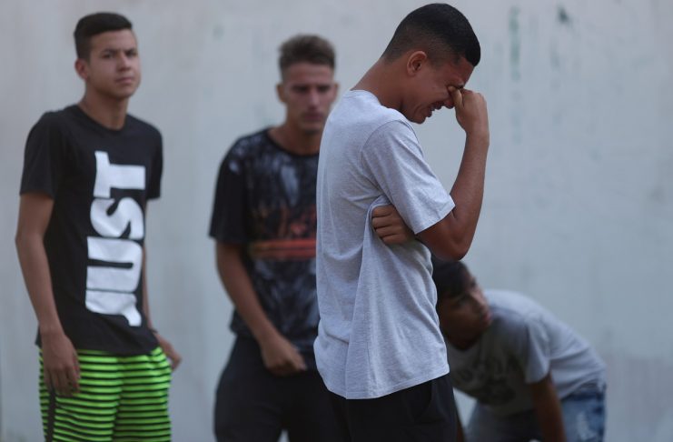 People wait for information in front of the training center of Rio’s soccer club Flamengo, after a deadly fire in Rio de Janeiro