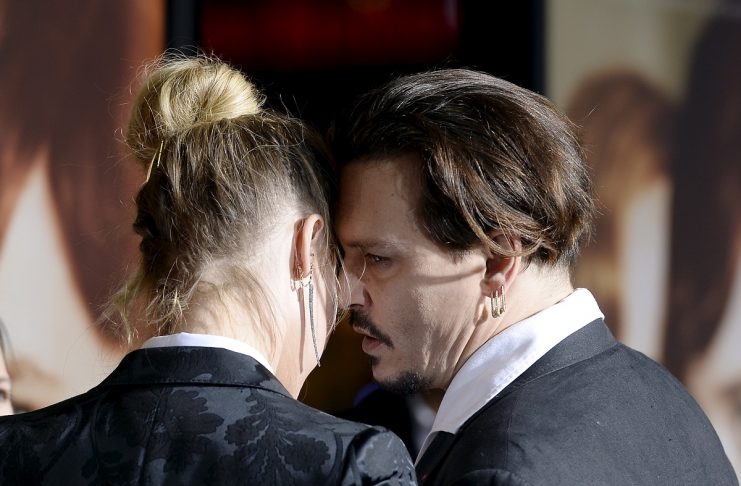 Cast member Amber Heard walks with husband Johnny Depp walk on the red carpet during the premiere of the film “The Danish Girl” in Los Angeles