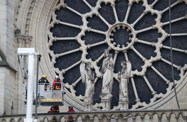 Firefighters work at Notre-Dame Cathedral after a massive fire devastated large parts of the gothic gem in Paris