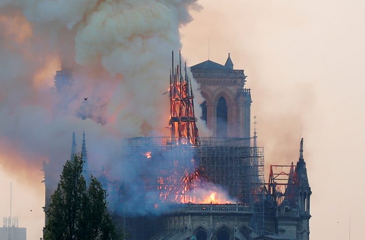 Smoke rises from the burning spire on the roof at the Notre-Dame Cathedral after a fire broke out, in Paris,